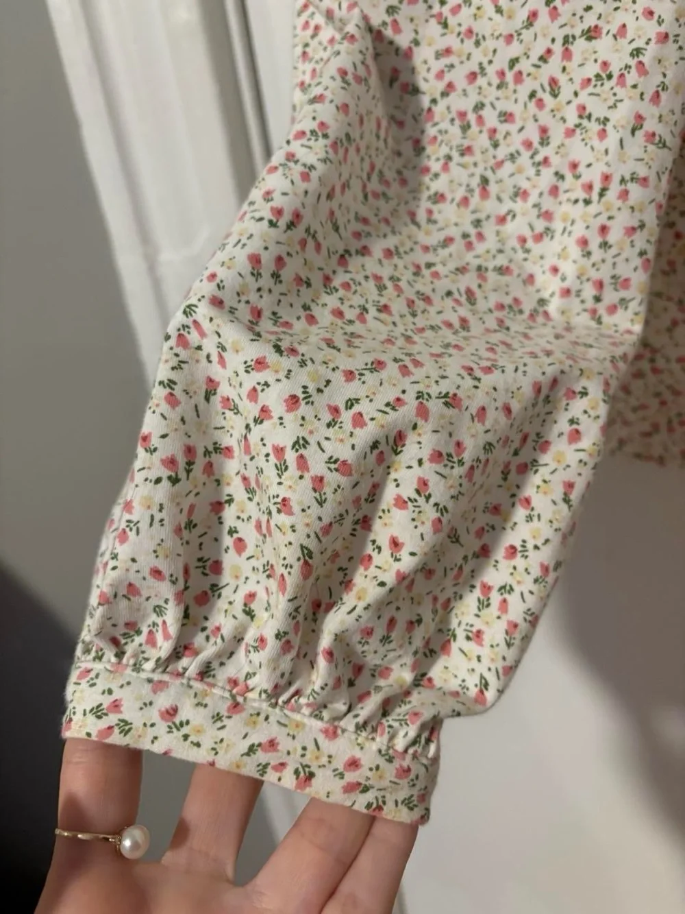 Anthropologie white cotton blouse with small pink ditzy floral print and ruffles